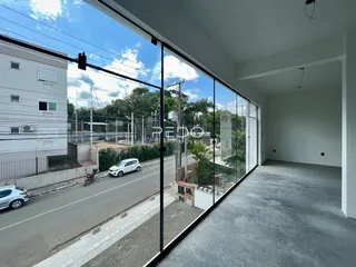 Vista da sala de estar com grandes janelas que dão para uma rua em Lajeado.