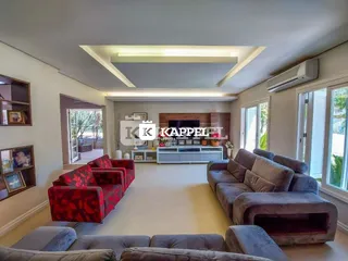Sala de estar ampla com sofás e lareira em um apartamento.