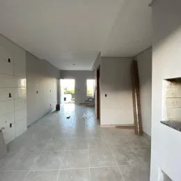 Foto de um corredor interno com piso de cerâmica claro.