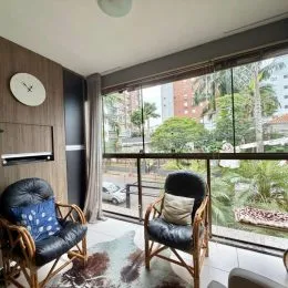Sala de estar com vista para o exterior através de grandes janelas.