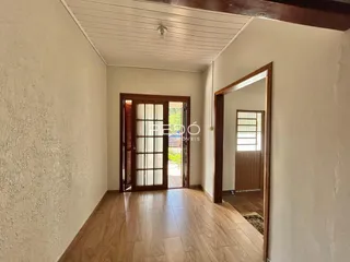 Hall de entrada com piso de madeira e porta de madeira.