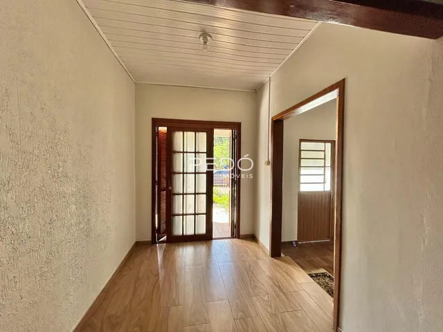 Hall de entrada com piso de madeira e porta de madeira.