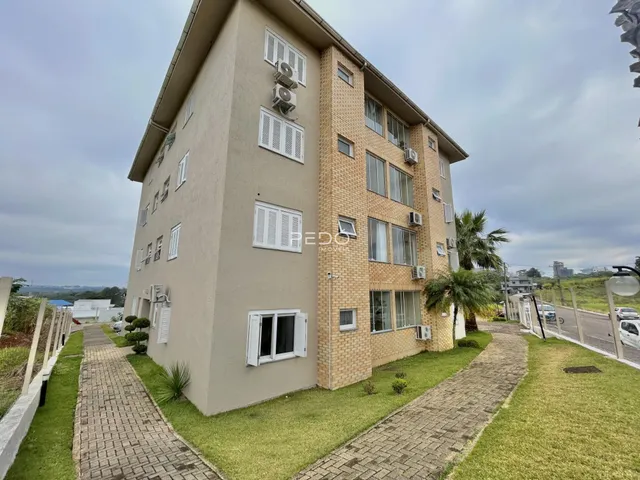 Fachada de um prédio residencial em Lajeado, Brasil com jardim e calçadas.