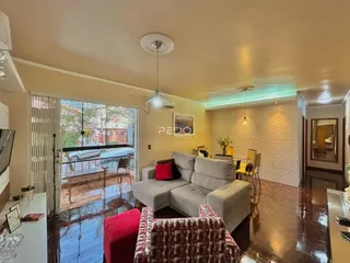Sala de estar com piso de madeira escura e porta de vidro abrindo para a área externa.