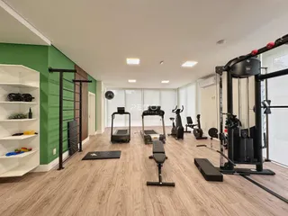 Ambiente interno de uma sala grande com equipamentos de ginástica.