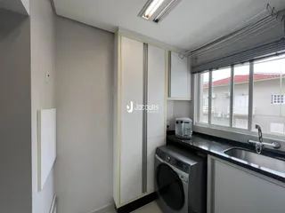 Foto de uma cozinha moderna com armários brancos e janela.