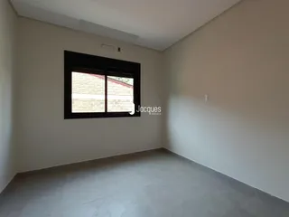 Interior de um cômodo com janela e paredes brancas.