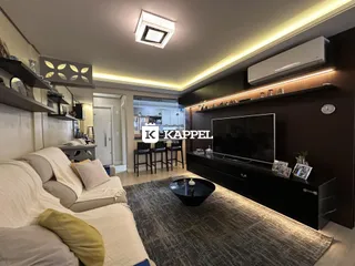 Sala de estar com cama e televisão em um apartamento.