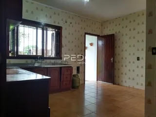 Interior de uma sala com piso de madeira e paredes texturizadas.