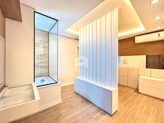 Foto de um banheiro moderno com box de vidro e piso de madeira clara.