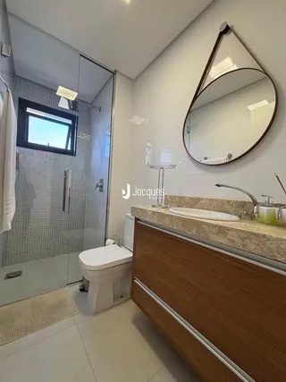 Foto de um banheiro moderno com bancada de madeira e piso claro.