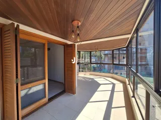 Ambiente interno com teto de madeira e vista para a varanda.