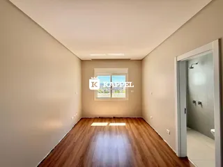 Sala de estar com piso de madeira e janela em um imóvel.