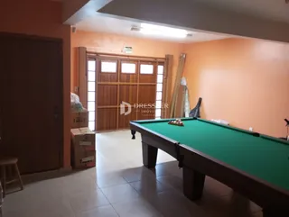 Interior de uma sala com uma mesa de bilhar em um imóvel no Brasil.