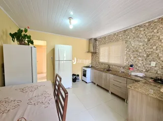 Foto interna de um quarto com piso de cerâmica e armário branco.