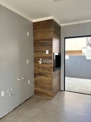 Foto de um corredor interno com parede de destaque de madeira escura.
