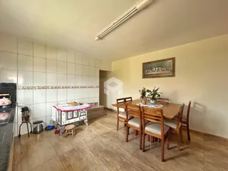 Foto de uma sala de jantar com mesa de madeira e piso de cerâmica.