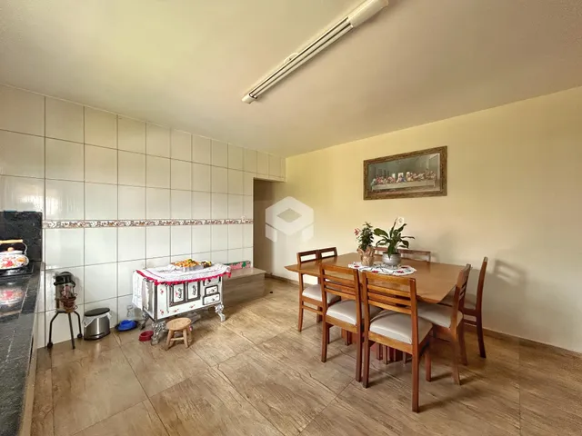 Foto de uma sala de jantar com mesa de madeira e piso de cerâmica.
