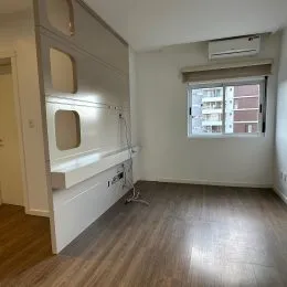 Quarto com parede branca e ar-condicionado instalado.