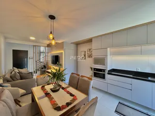 Sala de estar e cozinha moderna com armários brancos.