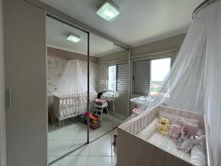 Quarto com cama e cortinas brancas refletidas em um espelho.