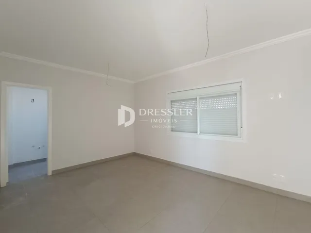 Ambiente interno de uma sala vazia com paredes brancas.