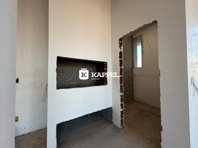 Foto de um ambiente interno com paredes de concreto aparente e estrutura em reforma.