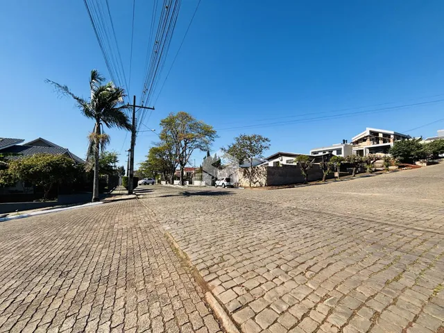 Vista da rua pavimentada em Lajeado, Brasil, com casas ao fundo.