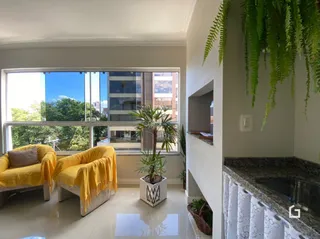 Sala de estar com grandes janelas e plantas na Lajeado.
