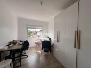Um quarto com janela e armário branco em um imóvel no Brasil.