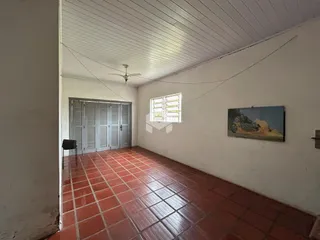 Corredor interno com piso de cerâmica avermelhada e portas de vidro.