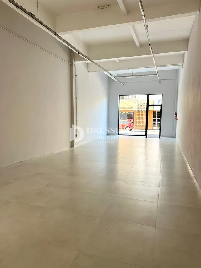Corredor interno de um imóvel com paredes brancas e piso claro.