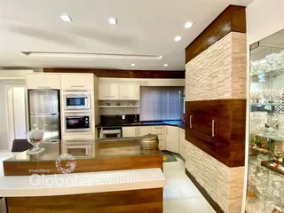 Cozinha moderna com armários brancos e detalhes em madeira.