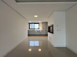 Hall de entrada com piso claro e paredes brancas.