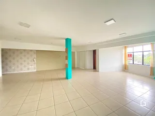 Ambiente interno amplo com piso de cerâmica clara em uma residência.