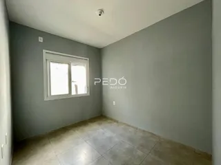 Ambiente interno de uma sala com paredes cinzas e piso de cerâmica.