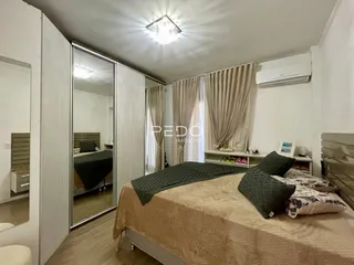 Quarto com cama e cortinas brancas.