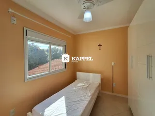 Um quarto com cama de casal e janela mostrando a iluminação interna.