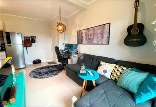 Sala de estar moderna com sofá cinza e piso claro.