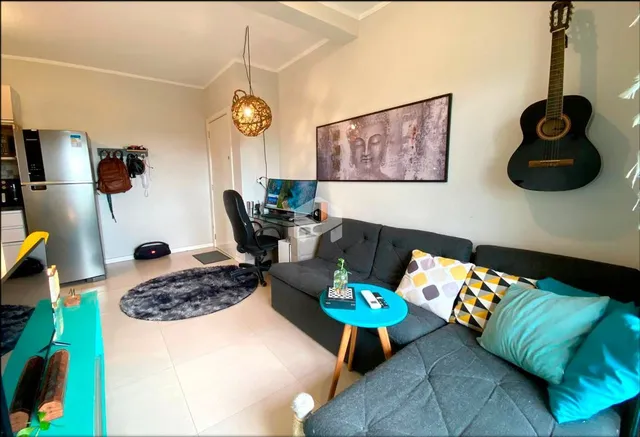 Sala de estar moderna com sofá cinza e piso claro.