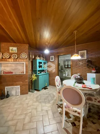 Ambiente interno de sala com piso de cerâmica e teto de madeira exposta.