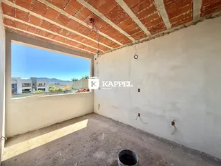 Vista interna de um cômodo com teto de tijolos expostos e uma grande abertura para a paisagem.