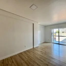 Ambiente interno com piso de madeira e grande janela.