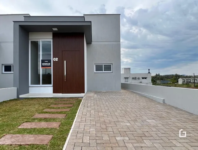 Fachada de uma casa moderna em Lajeado com área externa pavimentada.