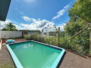 Foto de uma piscina externa em um quintal com vegetação.