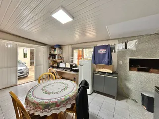 Uma sala de jantar com mesa e cadeiras é visível na imagem.