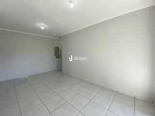 Ambiente interno de uma sala com piso de cerâmica e paredes brancas.