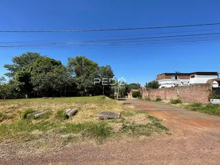 Vista externa de uma propriedade rural com vegetação seca e estrada de terra.