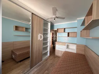 Quarto com armários embutidos e piso de madeira clara em um imóvel no Brasil.