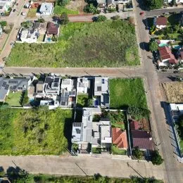 Vista aérea de uma propriedade com área verde e construções no entorno.